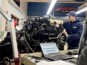 man working on boat engine during winterization service