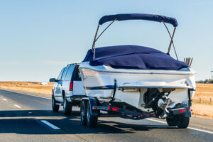 Boat being transported by trailer as part of concierge pickup and delivery for winter storage at Chester Boat Basin. 